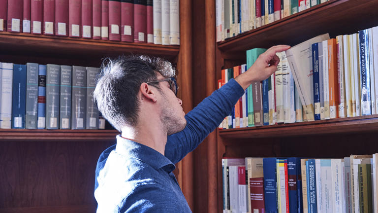 Student in library looking at books